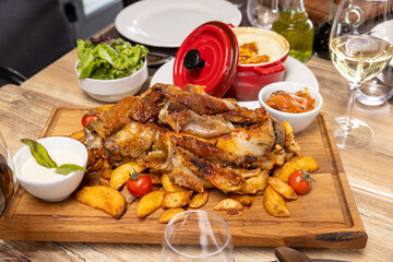 lamb chops served on a wooden board with potatoes