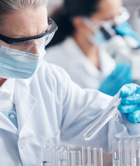 Mature, woman and ppe with test tube for medical, research and innovation in laboratory for...