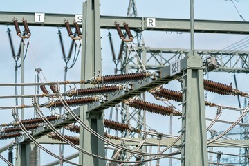Close-up of electrical substation components with insulators and wires