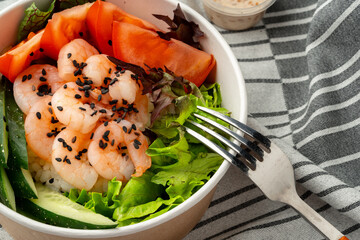 Poke bowl with shrimp on gray cloth close up