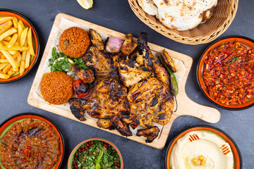 Grilled chicken wings served with different sauces and lemon. Black background. Top View Zoom Out.