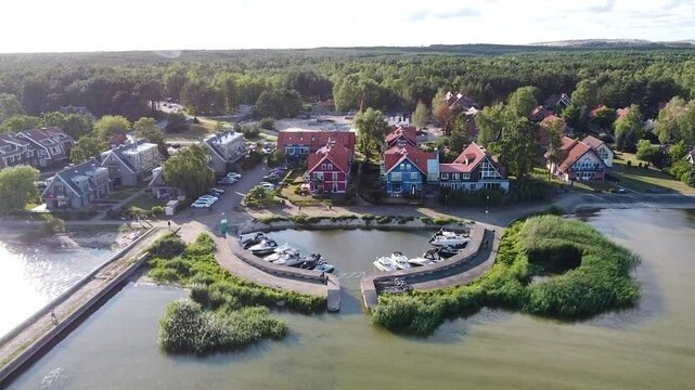 Aerial view of Pervalka, a village on the Curonian Spit in Lithuania, showcasing colorful houses and serene waters.