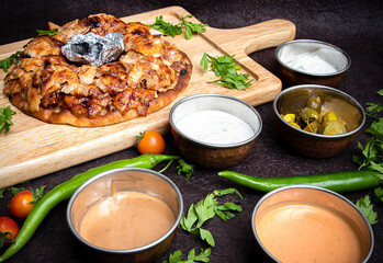 Turkish Iskender Shawarma Meat or beef or chicken with Charcoal in the center and sauces around. Cook fries grilled meat shawarma. Hot fresh delicious kebabs - a fine selection of street food.