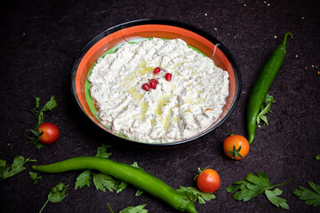 mutabal Turkish cuisine on wooden table with pomegranate