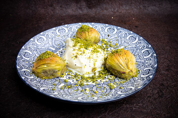 Delicious Turkish baklava served with pistachio cream and cream ice cream on a plate. Turkish Ramadan Dessert Baklava kadayif with ice cream concept background