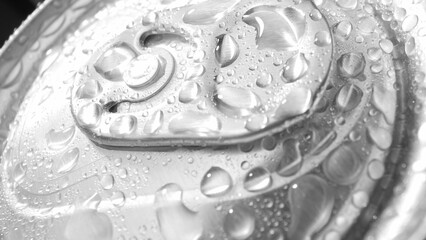 Each water droplet glistens atop the aluminum can, highlighting its smooth, reflective surface. The pull-tab opener stands out against the backdrop, inviting a refreshing sip. Metallic  background.
