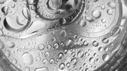 A close-up reveals the tantalizing sight of water droplets adorning the aluminum lid of the can, hinting at the refreshing drink within. The pull tab beckons for exploration. Beverage background.
