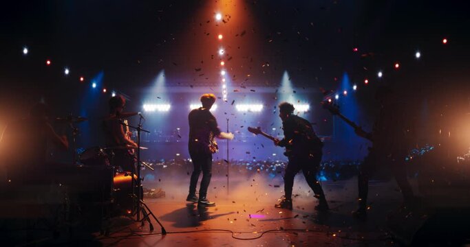 Young Indie Band Playing a Rock Music Gig with Alternative Punk Tracks at a Festival with Energetic Music Fans. Five Charismatic Musicians Make a Live Performance Under Falling Confetti