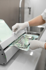 Packing and vacuuming medical instruments in bag for sanitazing in autoclave machibe in modern clinic