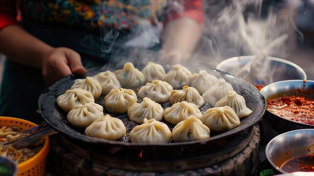 A street food vendor is cooking momos, a type of dumpling, in a large pan