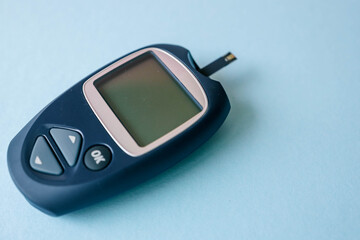 Glucometer top view on blue background