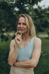 Fototapeta premium Apple woman. Very beautiful ethnic model eating green apple in the park.
