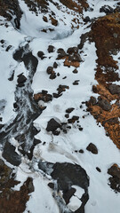 The magnificent Dynjandi waterfall in Iceland is covered in a stunning blanket of ice and snow, creating a truly breathtaking sight