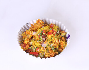 Bhel Puri is a savoury snack/Chaat item from India. It is made of puffed rice, vegetables & tangy tamarind sauce. Popular road side food. Served in bowl / plate over moody background. Selective focus