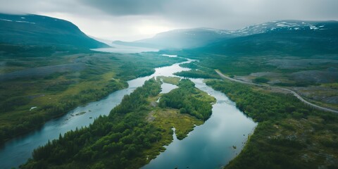 Fototapeta premium Misty forest envelops tranquil river valley, with panoramic views of mountains and serene lakes.