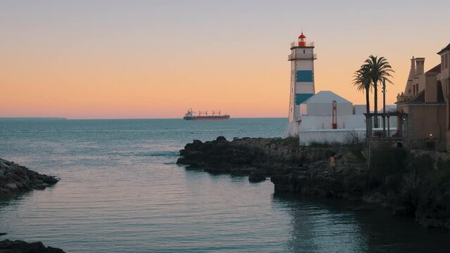A cinematic scene with a striped lighthouse, palms with sea, atlantic ocean. Beautiful sunrise sunset gradient colors. Dramatic evening, relaxing, chill, calm atmosphere. Small waves with reflections.