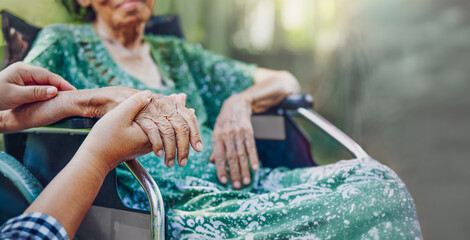 A Daughter's Love. Elderly asian woman on wheelchair at home with daughter take care.