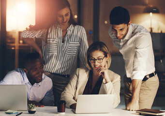 Business people, teamwork and night in office with laptop for deadline of project, strategy session and commitment for task. Corporate, employees and working late for overtime, online and research.