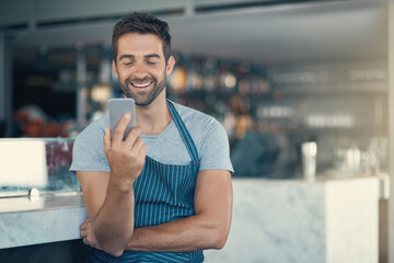 Barista, man and smartphone in cafe with apron for communication, networking or restaurant app....