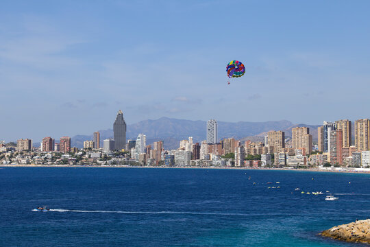 People parascending on Benidorm beach under blue sky