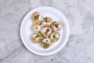 A plate of traditional Indian or Pakistani appetizer Dahi Puri, crispy shells stuffed with boiled potatoes and spices