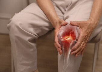 Hand holding knee with pain due to degenerative arthritis