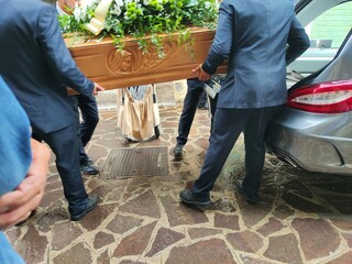 Hearse with gravediggers carrying the coffin