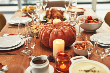 Thanksgiving, food and pumpkin on table in home for dinner party, celebration and family or social event. Cooking and closeup of feast, dish and gourmet meal for holiday, festive eating or lunch