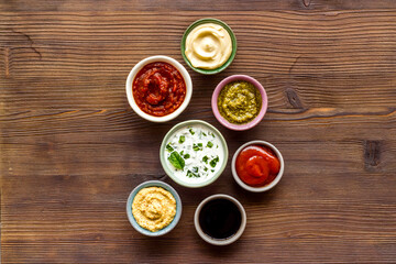 Set of sauces in bowls - pesto salsa mustard and others. Food background