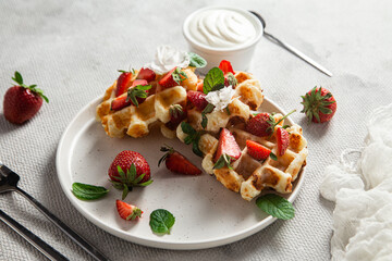 Belgian waffles with fresh strawberries in a plate. Viennese waffles