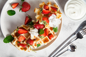Belgian waffles with fresh strawberries in a plate. Viennese waffles