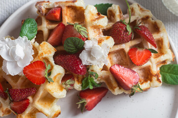 Belgian waffles with fresh strawberries in a plate. Viennese waffles