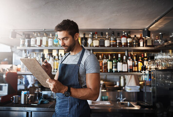 Bartender, writing and clipboard for restaurant management with stock, inventory or check for liquor. Person, barman and checklist with thinking, order or reading for alcohol, invoice or notes at pub