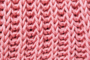 pink beautiful knitted braid pattern of light natural wool yarn, knitted texture, concept warm things for cold weather, knitting hobby, needlework, fashion clothes