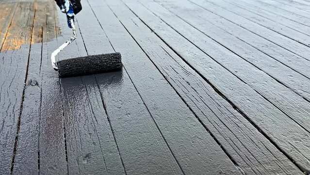 Painting a wooden deck with a roller