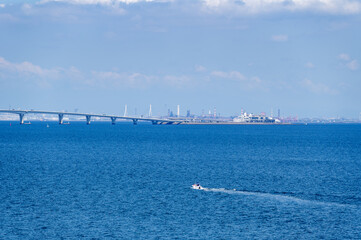 夏の日の東京湾の水平線とアクアラインと船