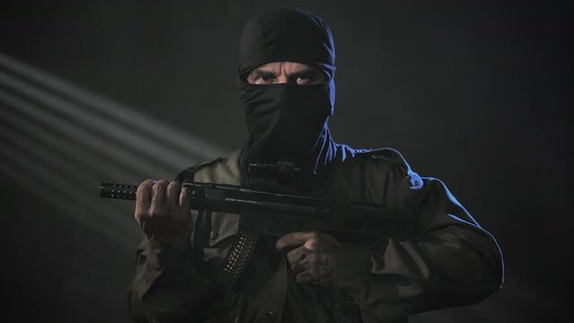 male soldier hooded holding machine gun looking at the camera,portrait of mercenary of special forces holding machine gun,private military contractor