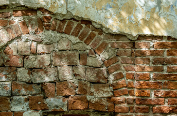 An old brick wall with crumbling plaster.