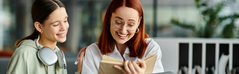 A tutor, a redhead woman, imparts knowledge to her teenage student, both engrossed in a book amidst...