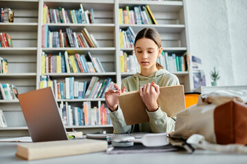 A teenage girl sits at a desk immersed in her laptop amidst a backdrop of bookshelves, deeply...