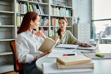 A tutor with fiery red hair conducts after-school lessons with a teenage girl using a laptop in a serene library setting.