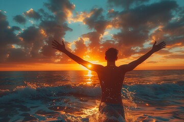 Fototapeta premium Person celebrating in the ocean at sunset with arms raised