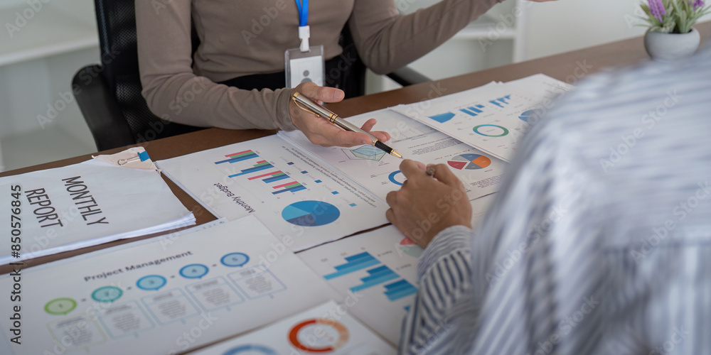 Aufkleber two business professional discussing planning and analysis with charts and graphs in a modern office