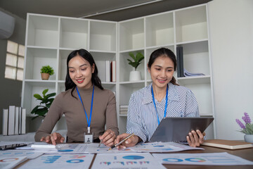 Two Business Professional Discussing Planning and Analysis in a Modern Office Setting with Charts and Graphs