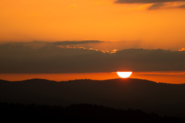 Beautiful sunset with clouds and orange sky. Mountain.
