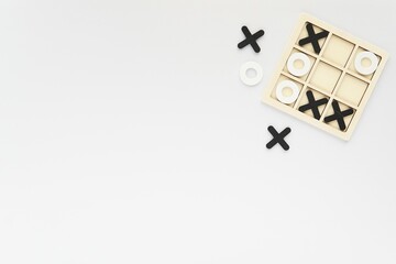 Wooden black and white tic-tac-toe board game on white background, competition, kids activity, brain games concept, free space for text.