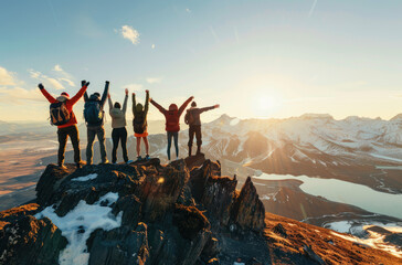 A group of people standing at the top of the mountain, cheering with their arms raised high in joy and victory. 