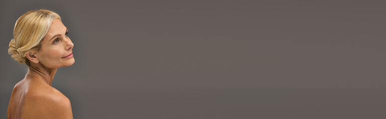 Pretty woman striking a pose against a gray background.