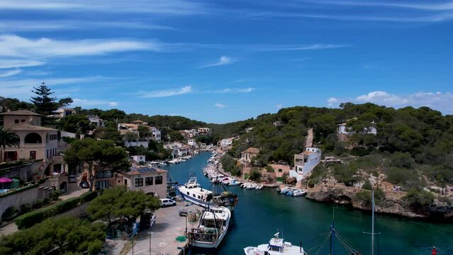 4K Aerial Drone video of a small fisherman town, a bay full of fishing boats with crystal clear turquoise water, Cala Figuera, Mallorca