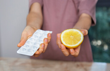 hands holding lemon and pills close-up. healthy lifestyle and dieting concept